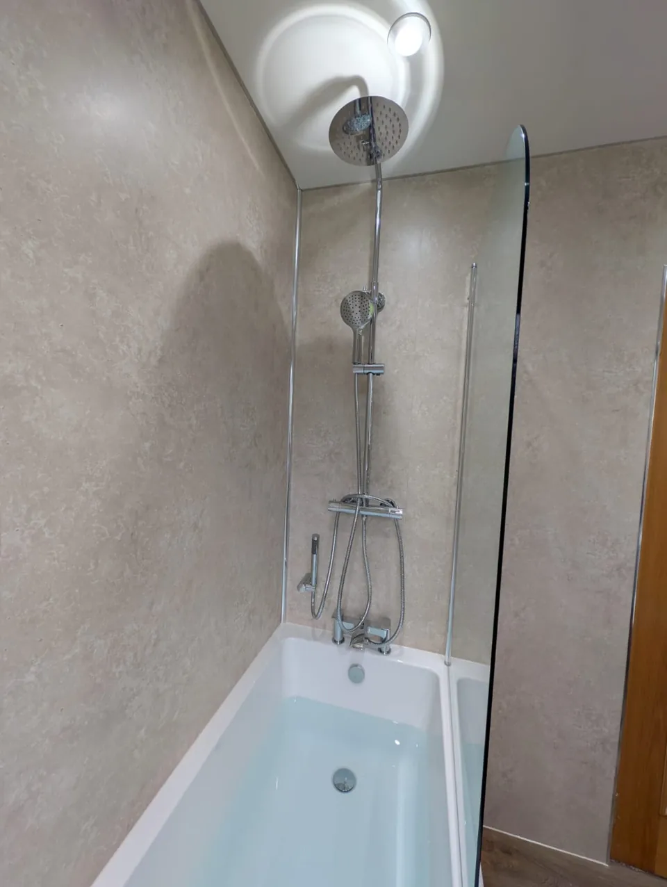 Shower over a white fitted bath with a clear screen