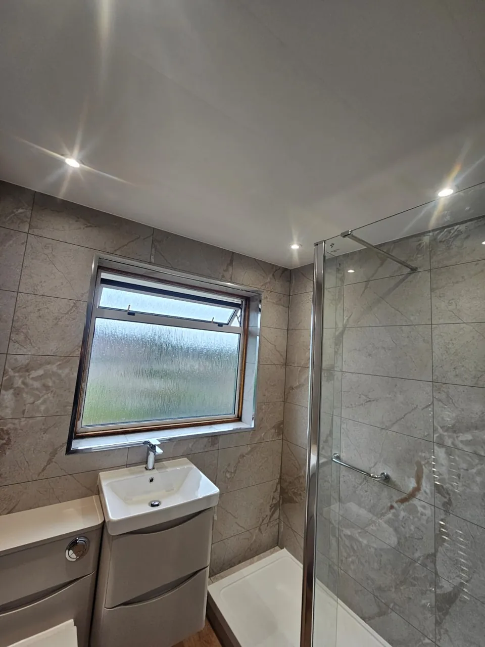 Shower room with white vanity and wood-effect flooring